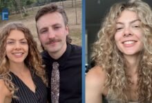 Nancy Mitchell smiling in her signature curly blonde hairstyle, standing next to her partner.
