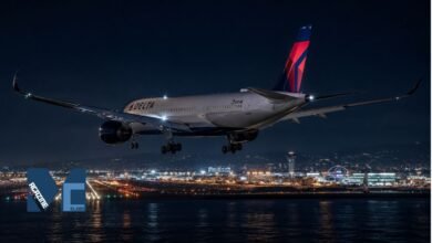 Rear view of a Delta Air Lines Airbus A350-900 widebody aircraft with landing gear extended, executing a nighttime landing approach over the water into Los Angeles International Airport LAX with city lights and the iconic terminal structures illuminated in the background.