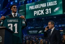 Philadelphia Eagles first-round pick Jihaad Campbell holding his number 31 draft jersey alongside general manager Howie Roseman negotiating the eagles rookie trade attempt on the phone.