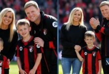 Eddie Howe smiling with his wife Vicki Howe and their two elder sons, Rocky and Harry Howe, wearing AFC Bournemouth kits on the pitch.
