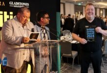 Gary Carr, Director of Empira Ltd, standing at the podium and celebrating a win at the British Parking Awards event.