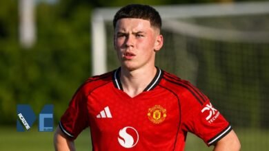 Kai Rooney wearing the red Manchester United youth kit on the training pitch with a football goal net visible in the background.