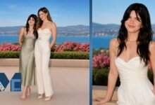 Mae Sandler posing alongside her mother Kathryn Hahn at an outdoor coastal event with scenic ocean views and floral surroundings.