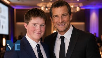 Marmaduke Mickey Percy Grylls standing next to his father Bear Grylls at a formal event, both wearing suits.