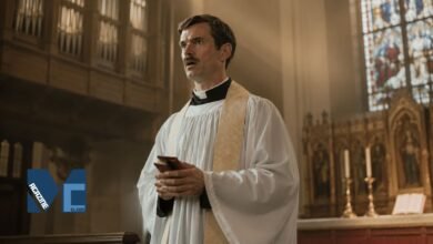 Actor Patrick Carr, younger brother of Jimmy Carr, dressed as a priest holding a small red book in a church setting.