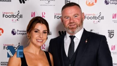Wayne Rooney and his wife Coleen Rooney smiling together at the Legends of Football event red carpet with Premier League logos in the background.