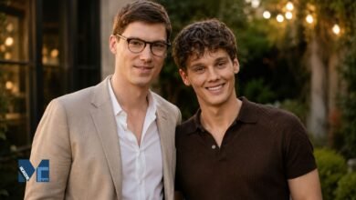 Litigation attorney Fielder Jewett in a beige blazer and glasses standing next to his husband, actor Hunter Doohan, smiling at an outdoor evening event.