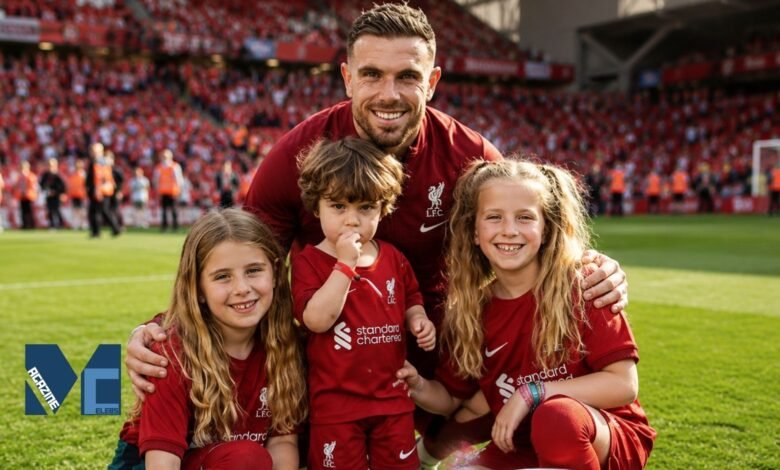 Former Liverpool captain Jordan Henderson smiling on the Anfield pitch surrounded by his three children, including his eldest daughter Elexa Henderson, all wearing Liverpool kits.