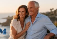 Kirsten Kutner standing next to her husband Greg Norman on a balcony overlooking the coast during sunset, featured on MagazineCelebs.