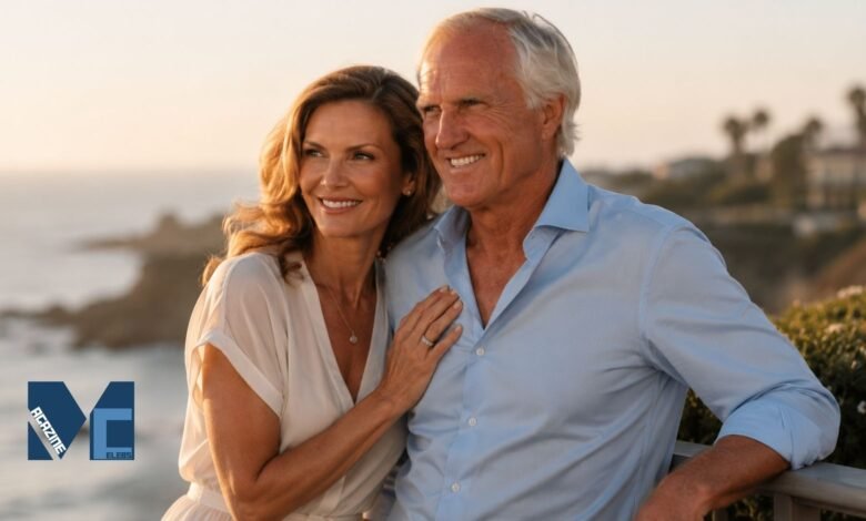 Kirsten Kutner standing next to her husband Greg Norman on a balcony overlooking the coast during sunset, featured on MagazineCelebs.