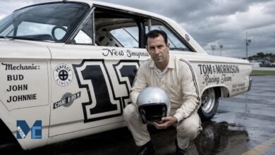 Ned Jarrett posing beside his iconic NASCAR race car number 11 while holding a racing helmet on a cloudy race day.