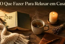 An aesthetic flat-lay of home relaxation items on a bed including an open journal with pen, a warm mug of coffee, a burning candle, and a green plant under soft warm lighting.