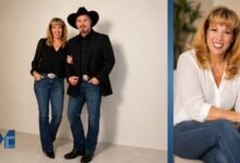 Sandy Mahl smiling in a casual portrait wearing a white blouse and blue jeans in a warm indoor setting.
