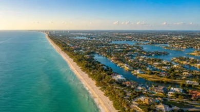 An aerial panoramic view of the beautiful Southwest Florida coastline within the 239 area code region, showing luxury waterfront properties, white sand beaches, and deep blue Gulf waters.