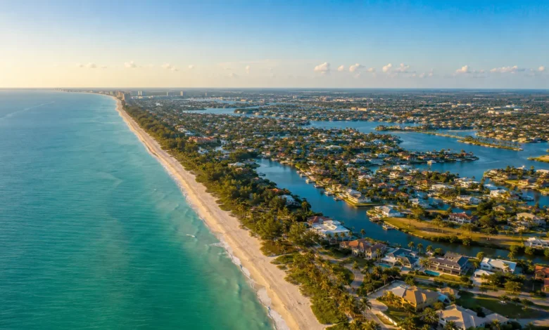 An aerial panoramic view of the beautiful Southwest Florida coastline within the 239 area code region, showing luxury waterfront properties, white sand beaches, and deep blue Gulf waters.